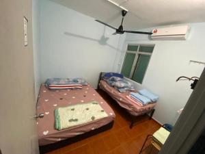 Kampong Tanah MerahMr Singh Homestay的小房间设有两张床和窗户
