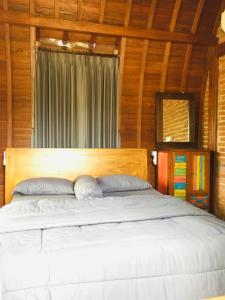 克拉玛斯Kubu Pering的一间卧室配有一张大床和木制床头板