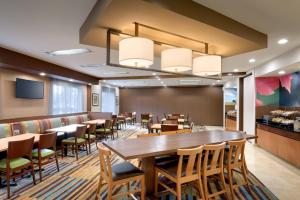 盐湖城盐湖城机场汉普顿套房酒店的餐厅设有一张大型木桌和椅子
