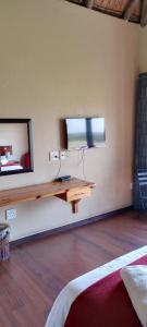 塞昆达ThakhuBrunfelsia的一间墙上配有电视的房间,配有桌子