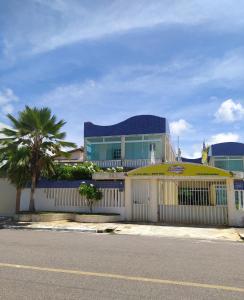 阿拉卡茹Pousada Aruamar的一座白色围栏和棕榈树的建筑