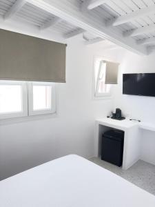 米克诺斯城Alana Mykonos的白色的客房配有一张床和一张书桌