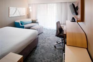 桑兹顿里士满机场万怡酒店的酒店客房配有床、沙发和电视。