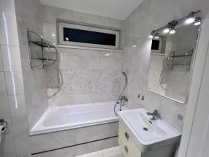 科希策Monte Amnis Kosice Apartment的白色的浴室设有浴缸和水槽。