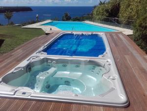 德赛Chambre d'hotes "Villa Rayon Vert"的游泳池旁甲板上的热水浴池