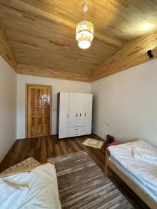 契拉勒Villa Nar的一间卧室设有两张床和木制天花板