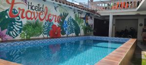 圣克鲁斯Hostal Backpackers Travelero的一座建筑的一侧,设有一座带壁画的游泳池