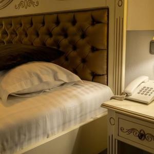札勒乌Grand Hotel Baroc的一间卧室配有一张带电话和一张桌子的床