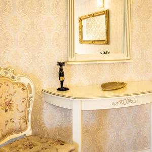札勒乌Grand Hotel Baroc的配有桌子、镜子和椅子的房间