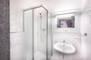新明斯特菲兹拉弗酒店的白色的浴室设有水槽和淋浴。