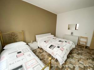 加维拉泰Appartamento Bellavista - Fronte Lago di Varese的一间卧室配有两张床和镜子