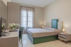 圣维托罗卡波吉卜力酒店的一间卧室配有一张床、一张书桌和一台电视