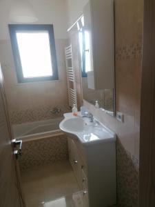 加拉蒂纳Albachiara的一间带水槽和浴缸的浴室以及窗户。