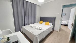 弗洛伊塔Vasileiadou Coastal Rooms的一间卧室配有一张带黄色枕头的床。