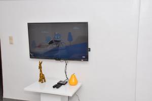 科托努Tranquillité Cotonou的挂在白色墙壁上的平面电视