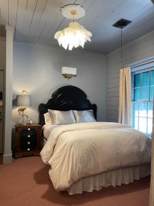 威诺纳Carriage House Bed & Breakfast的一间卧室配有一张大床和一个吊灯。