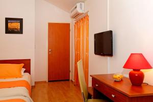 尼亚卢卡Guest House Kod Peskarije的一间卧室配有一张床、一张书桌和一台电视。