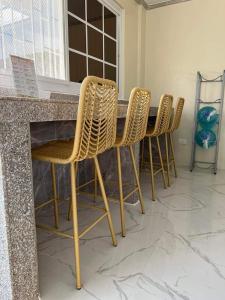 BolinaoMichaels Homestay - Farm Villa nr Patar Beach & Bolinao Falls的坐在一张桌子上的一组椅子