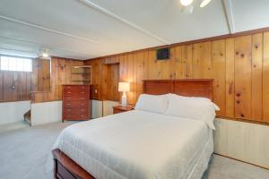 Chic Home with Deck, Walk to Lake Erie!的一间卧室设有一张床和木墙