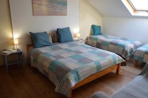 拉苏特兰Le Puy Robin的一间卧室配有两张带蓝色枕头的床