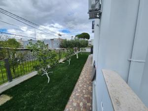 伏罗拉Vila Anxhelo&Xhemi的房子旁边的草坪上一排树木
