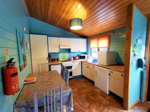 新卡姆诺克Glen Bay - 2 Bed Lodge on Friendly Farm Stay with Private Hot Tub的一间带桌子的厨房和一间带蓝色墙壁的厨房
