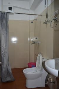 Namchi瞻博公寓酒店的浴室配有卫生间、盥洗盆和淋浴。