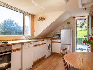 金斯布里奇Goody的厨房配有白色橱柜、桌子和窗户。