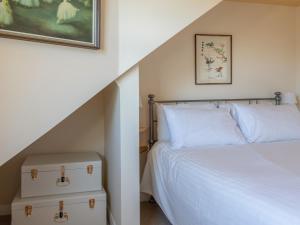 金斯布里奇Goody的卧室配有白色的床和楼梯间
