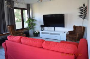 格罗尔斯泰因Dolomitenblick的客厅配有红色沙发和平面电视