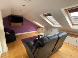 戈尔韦Apartment at Island Cottage, Inishnee, Roundstone的客厅配有真皮沙发和电视