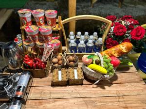 芹蒢SAY Camp Forest的一张木桌,上面有食物和蔬菜篮子