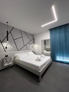 利多波波萨B&B A due passi dal mare的卧室配有白色的床和蓝色窗帘