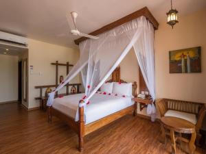 南威Nungwi Beach Resort by Turaco的一间卧室配有一张带天蓬的床