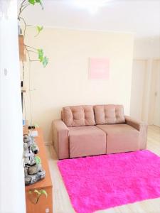 卡诺阿斯Pôr do Sol 8 andar的客厅配有粉红色的沙发和粉红色的地毯。