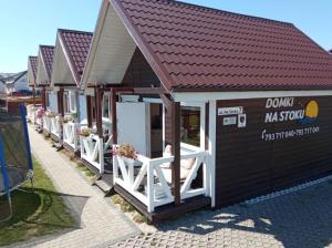 弗瓦迪斯瓦沃沃Domki letniskowe Na Stoku的白色门和红色屋顶的小建筑