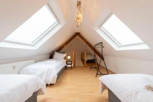 HauStay and Work Apartment - 8 single beds - Garage的阁楼卧室设有两张床和天窗。