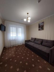 卡缅涅茨-波多利斯基Apart-hotel 24/7的带沙发和窗户的客厅