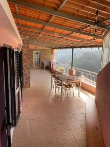 库拉尔-达斯弗雷拉斯Vivenda Ribeiro - Curral das Freiras的带阳台的带桌椅的房间