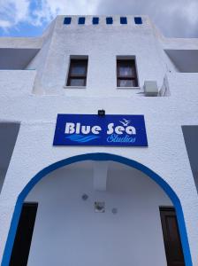 阿尔卡萨Blue Sea Studios的白色的建筑,上面有蓝色的标志