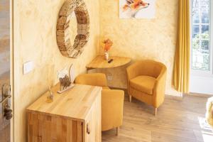 圣马丹韦叙比耶拉本青年旅馆 的客厅配有桌子、两把椅子、一张桌子和一张沙发