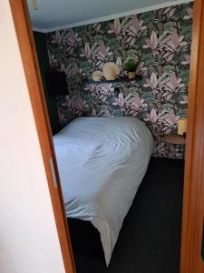 VledderKnusse chalet in een schitterende omgeving的花卉壁画房间内的小床