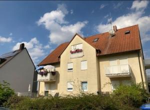纽伦堡Complete Apartment peacefully situated near the Airport Nürnberg的窗户上放着花盒的房子