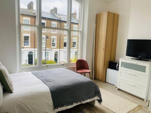 伦敦Studio close to Camden的一间卧室设有一张床和一个大窗户