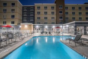 盖恩斯维尔Fairfield Inn & Suites by Marriott Gainesville I-75的一个带椅子的游泳池和一间酒店