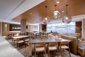 盐湖城SpringHill Suites by Marriott Salt Lake City Sugar House的一间带桌椅的餐厅和一间酒吧