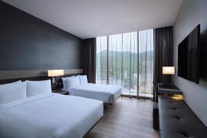 蒙特雷AC Hotel by Marriott Monterrey Valle的酒店客房设有两张床和大窗户。