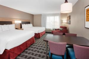 泰特斯维尔TownePlace Suites by Marriott Titusville Kennedy Space Center的酒店客房带两张床和一张桌子以及椅子。