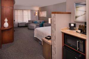 千橡市范杜拉县千橡市庭院酒店的酒店客房,配有床和沙发