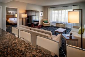 巴伯斯维尔Delta Hotels by Marriott Huntington Mall的酒店客房设有一张特大号床和一间客厅。